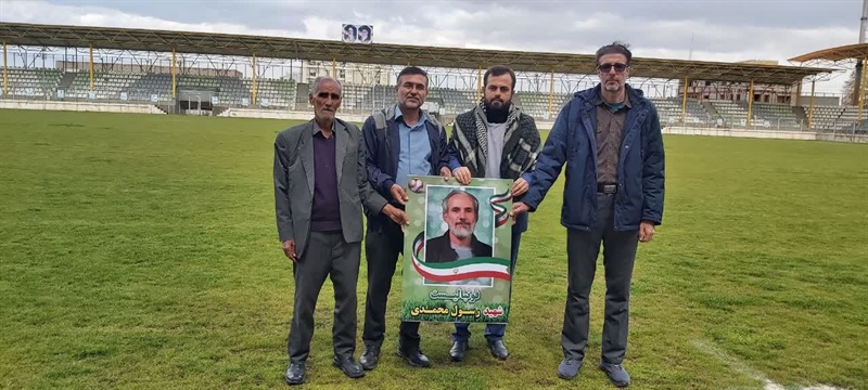 نصب تصویر شهید رسول محمدی در محوطه زمین چمن مجموعه ورزشی شهیدان حاجی بابایی شهر مریانج
